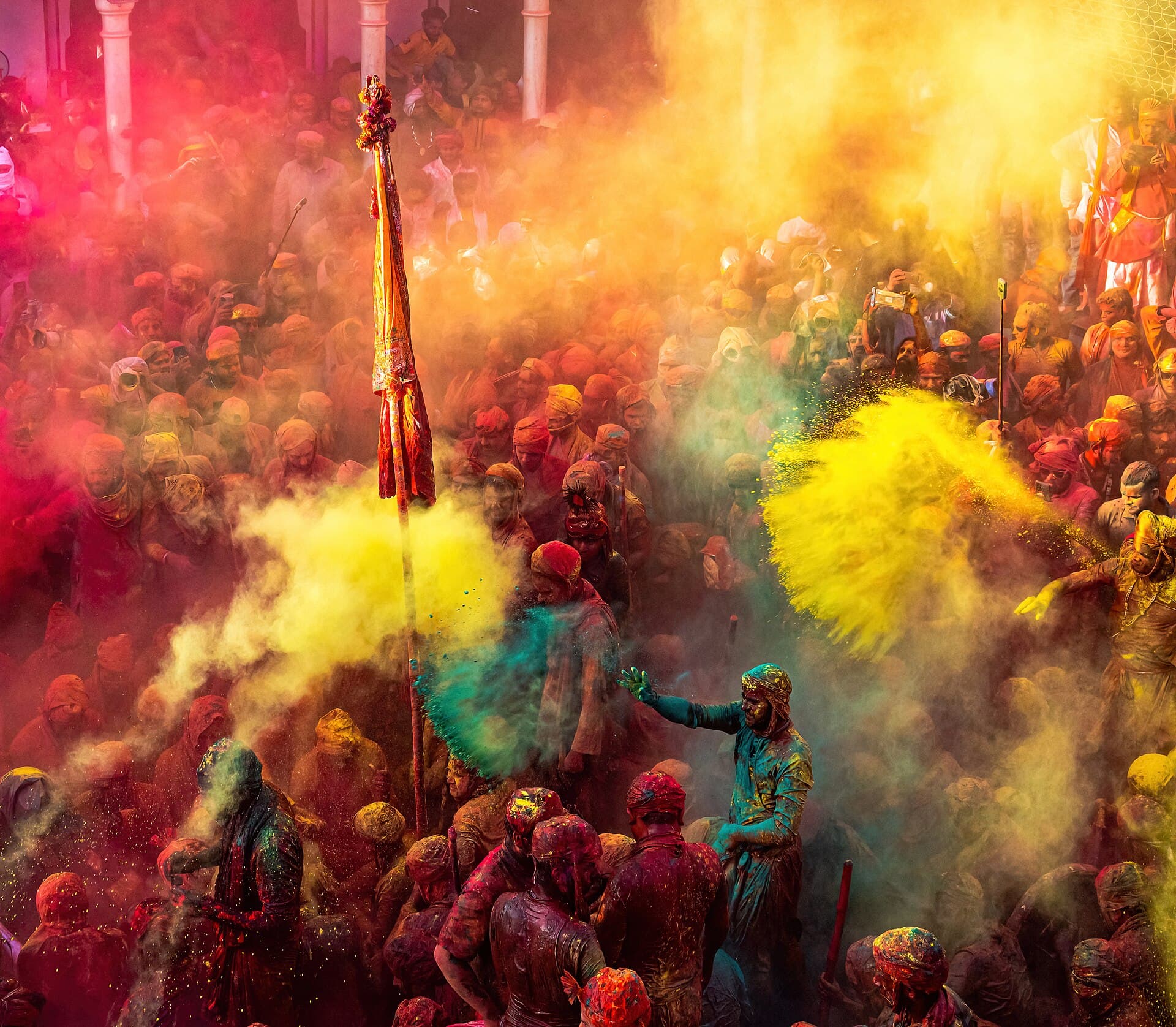 Crowds throwing bright colour powder during Holi in Uttar Pradesh